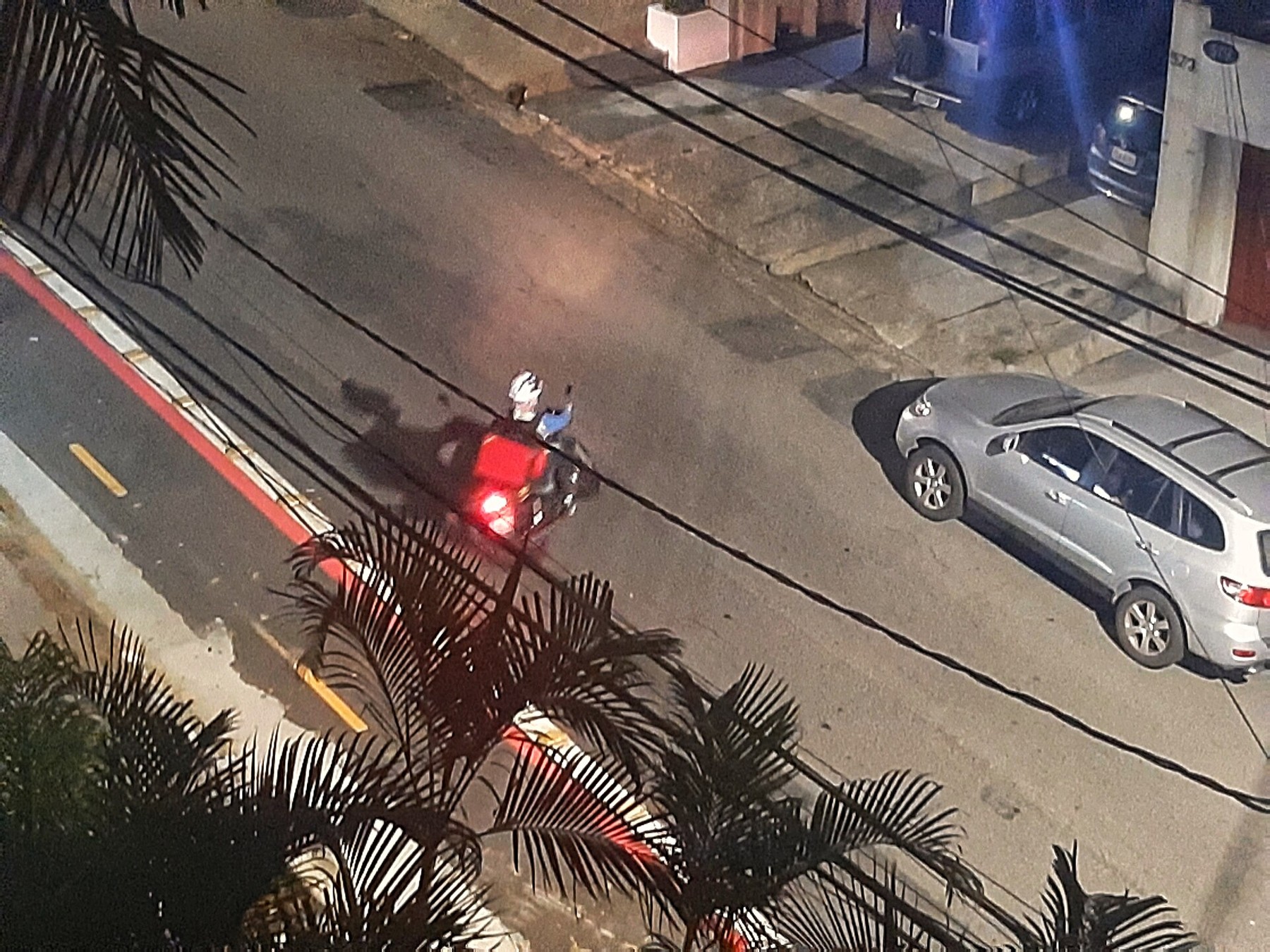 Entregador de aplicativo em motocicleta em rua de São Paulo