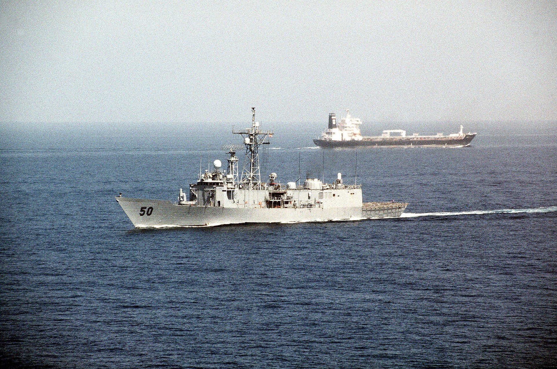 Navio de guerra americano e petroleiro no Estreito de Ormuz